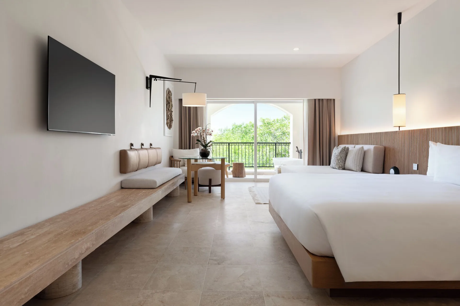 Guest room with two beds and balcony doors at Hacienda Tres Rios Resort, Spa & Nature Park.