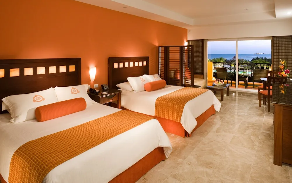 Guest room with two beds and ocean-facing balcony at Hacienda Tres Rios Resort, Spa & Nature Park.