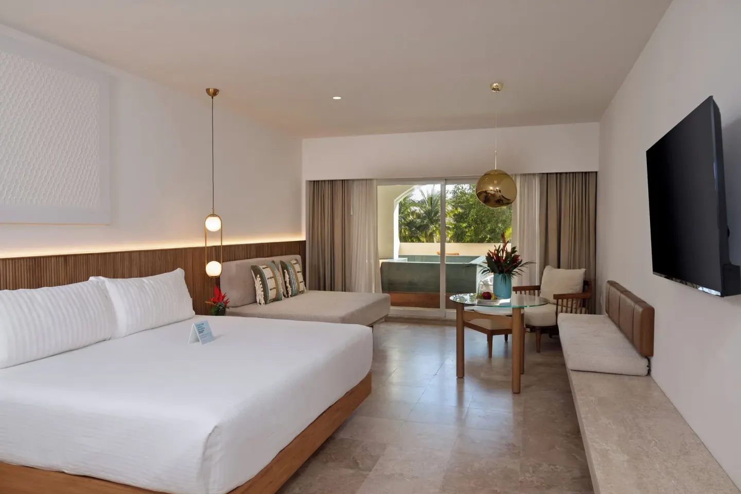 King bed guest room with wall TV at Hacienda Tres Rios Resort, Spa & Nature Park.