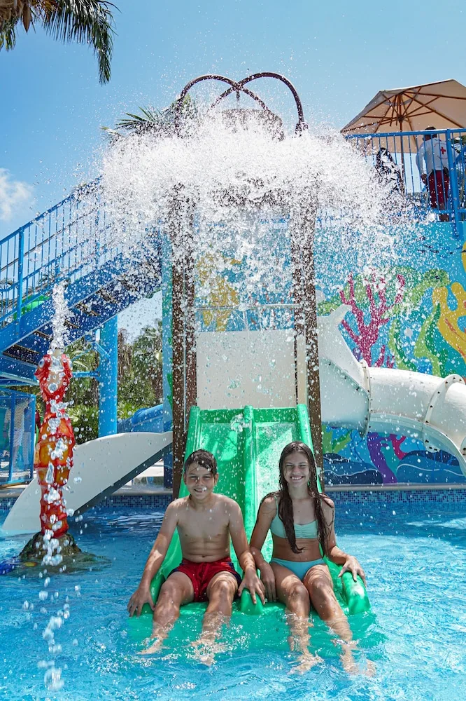 Children sit on a splash play slide at Hacienda Tres Rios Resort, Spa & Nature Park.