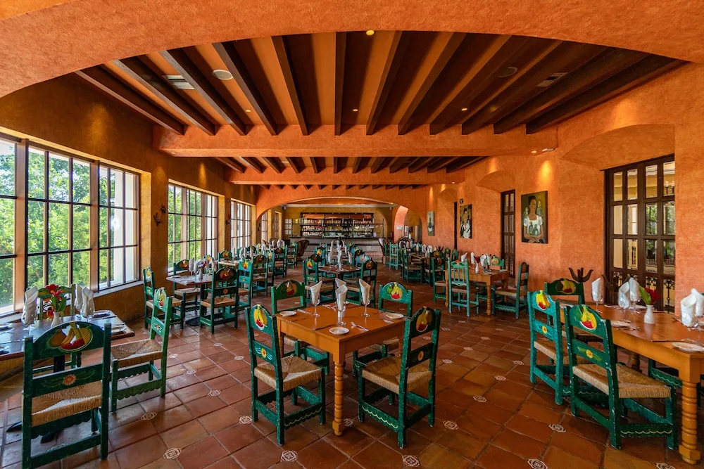 Mexican-style restaurant with painted chairs at Hacienda Tres Rios Resort, Spa & Nature Park.