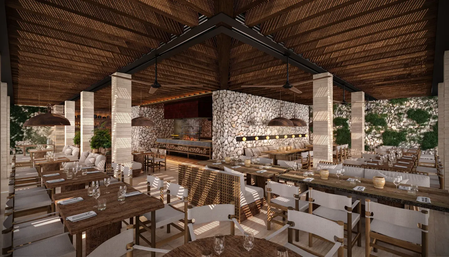 Open-air dining room with wood tables and stone walls at Hacienda Tres Rios Resort, Spa & Nature Park.