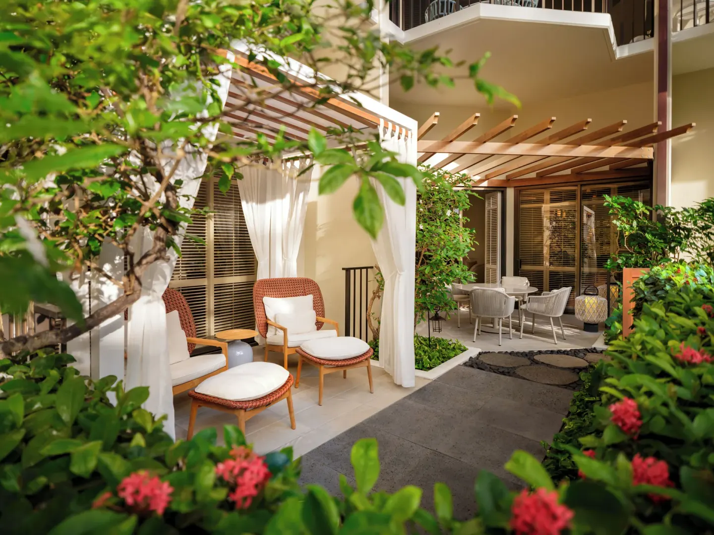 Garden patio seating with curtained cabana and flowers at Halekulani.