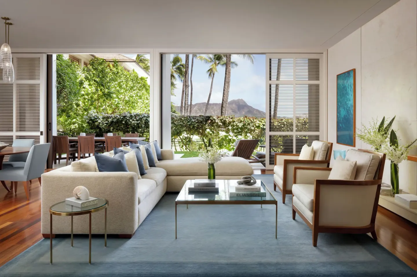Living room opening to a terrace with outdoor dining and Diamond Head view at Halekulani.