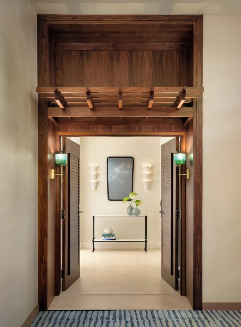 Wood-framed entryway at Halekulani opening into a softly lit interior hall.