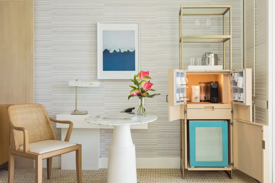 Guest room refreshment cabinet and table with flowers at Halekulani.