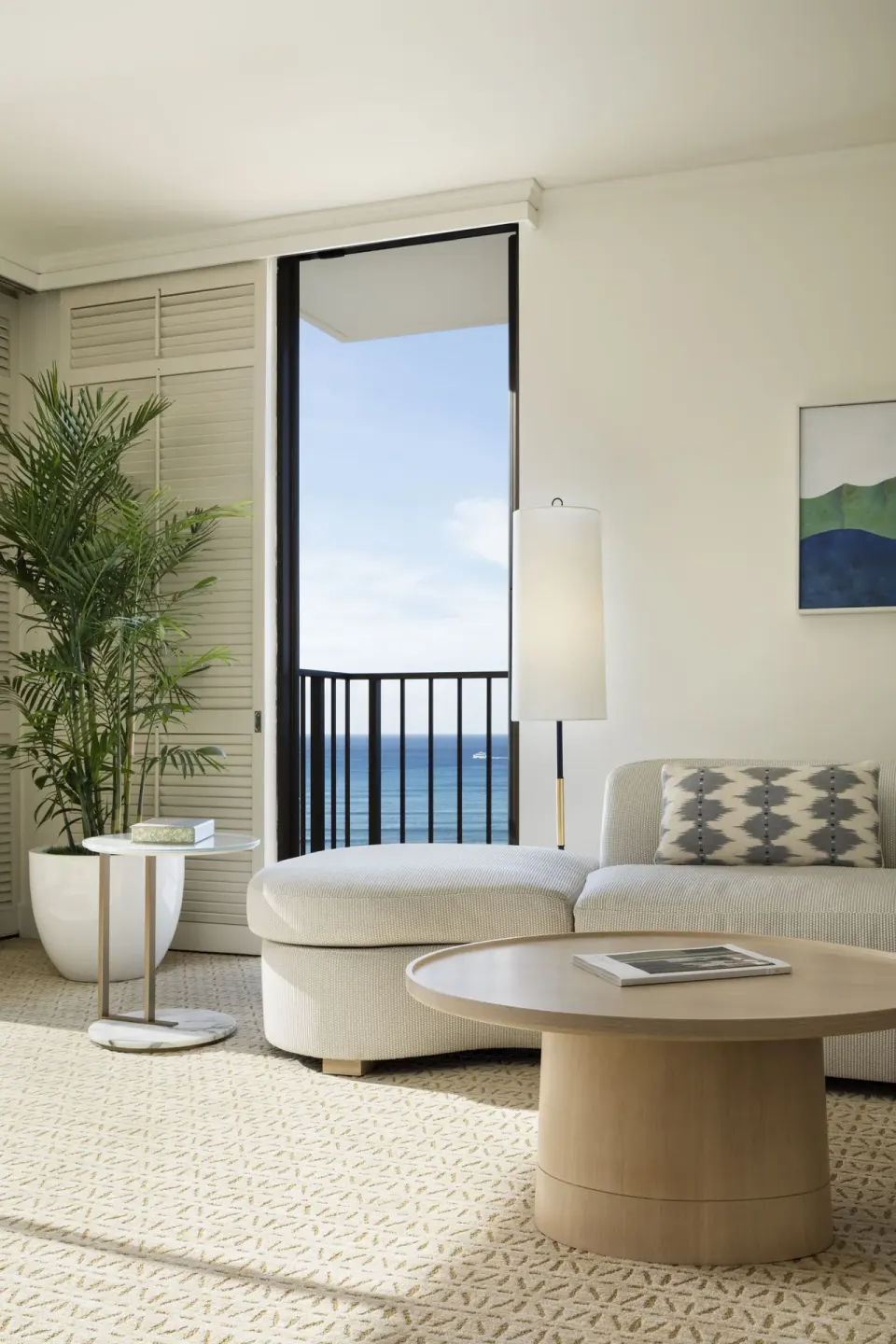 Suite sitting area with ocean-facing lanai door at Halekulani.