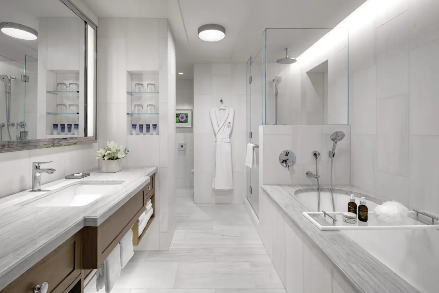 Marble bathroom with soaking tub and glass shower at Halepuna Waikiki by Halekulani.