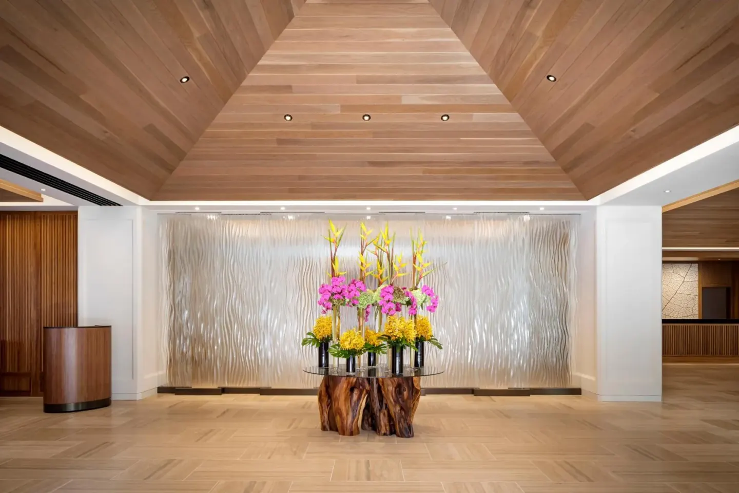 Lobby floral arrangement beneath a wood ceiling at Halepuna Waikiki by Halekulani.