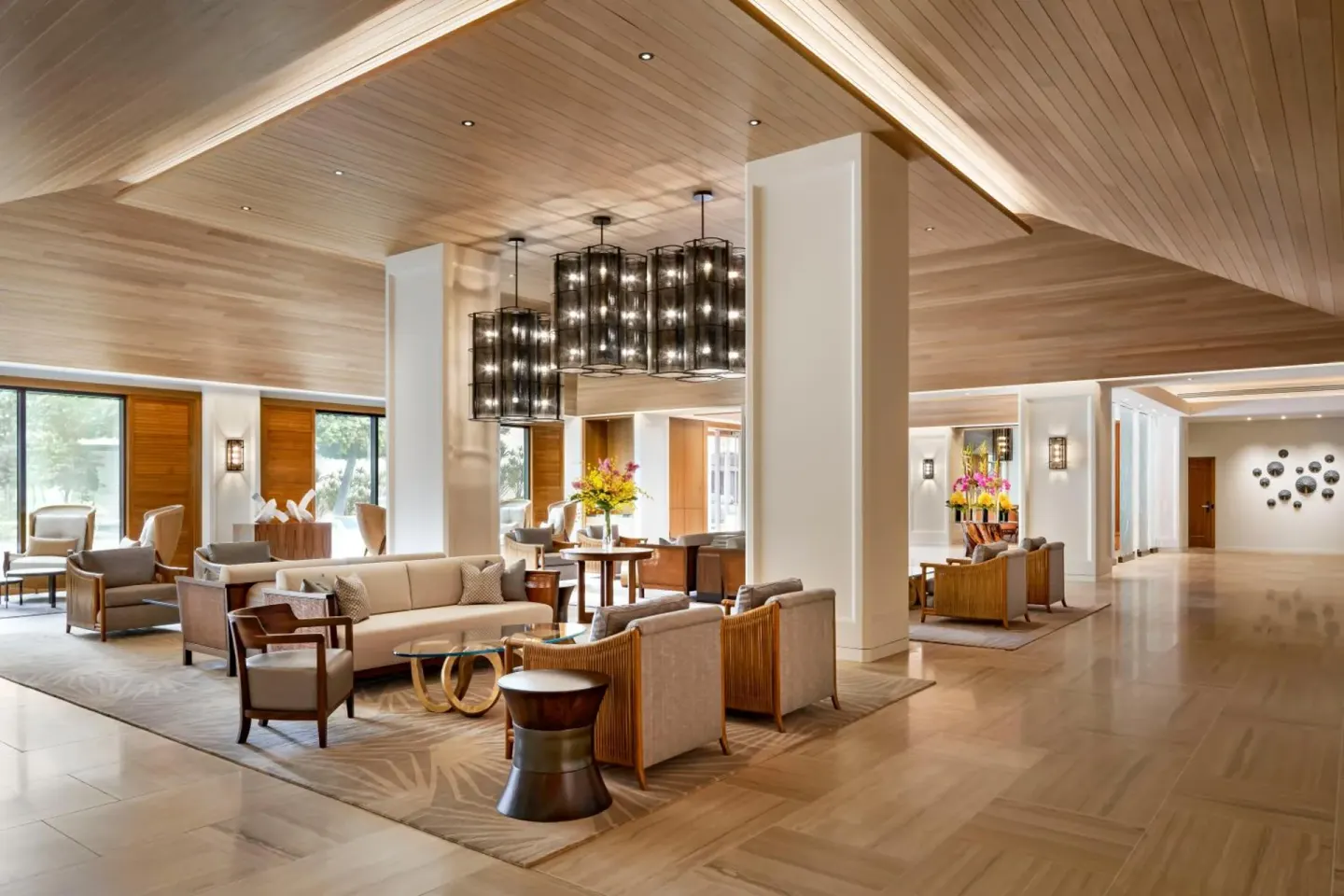 Lobby lounge with sofas, armchairs, and pendant lighting at Halepuna Waikiki by Halekulani.