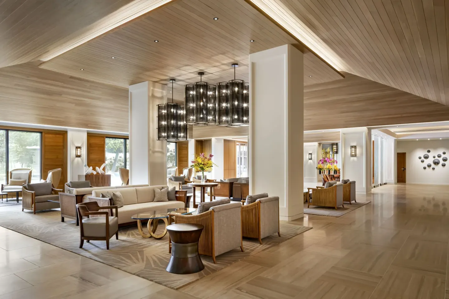 Lobby lounge seating with chandeliers and wood ceiling at Halepuna Waikiki by Halekulani.