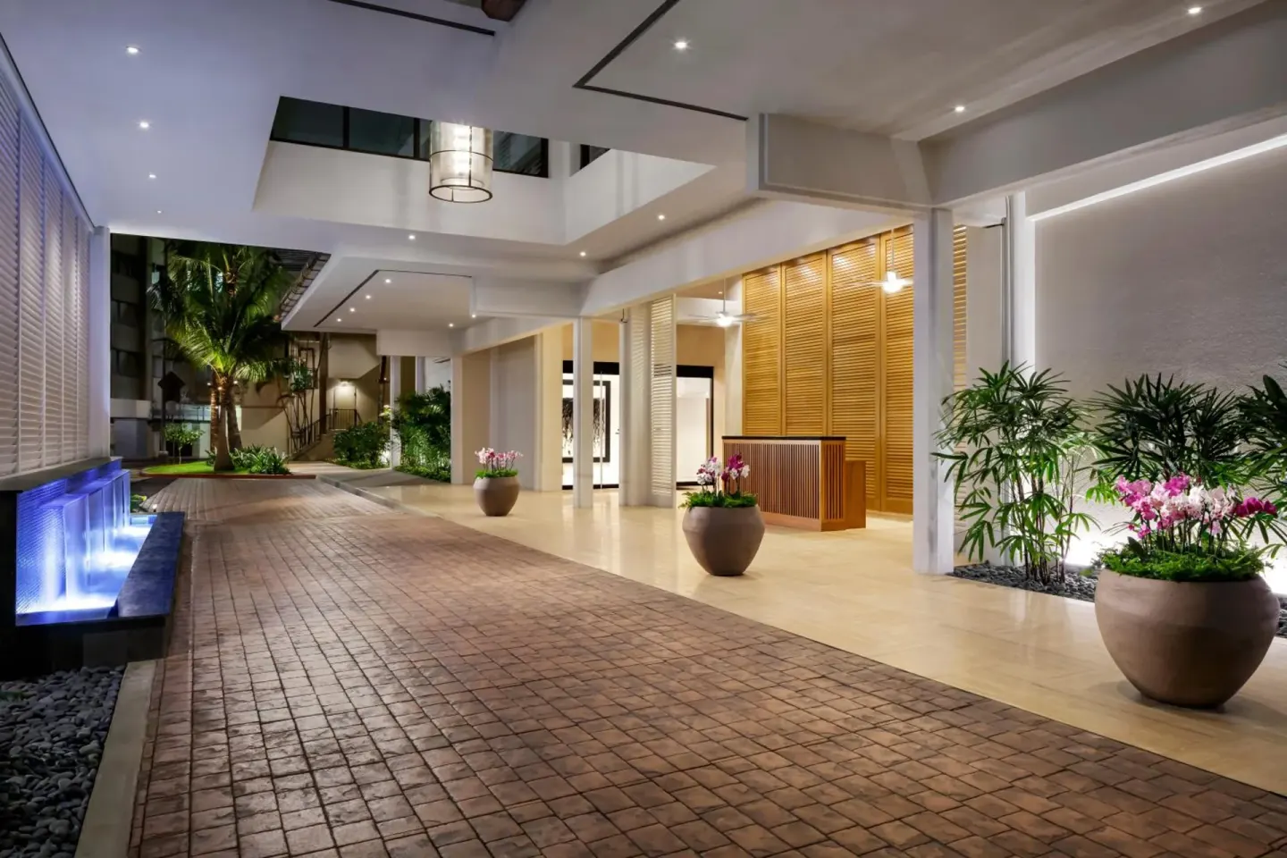 Illuminated driveway entrance and planters at Halepuna Waikiki by Halekulani.