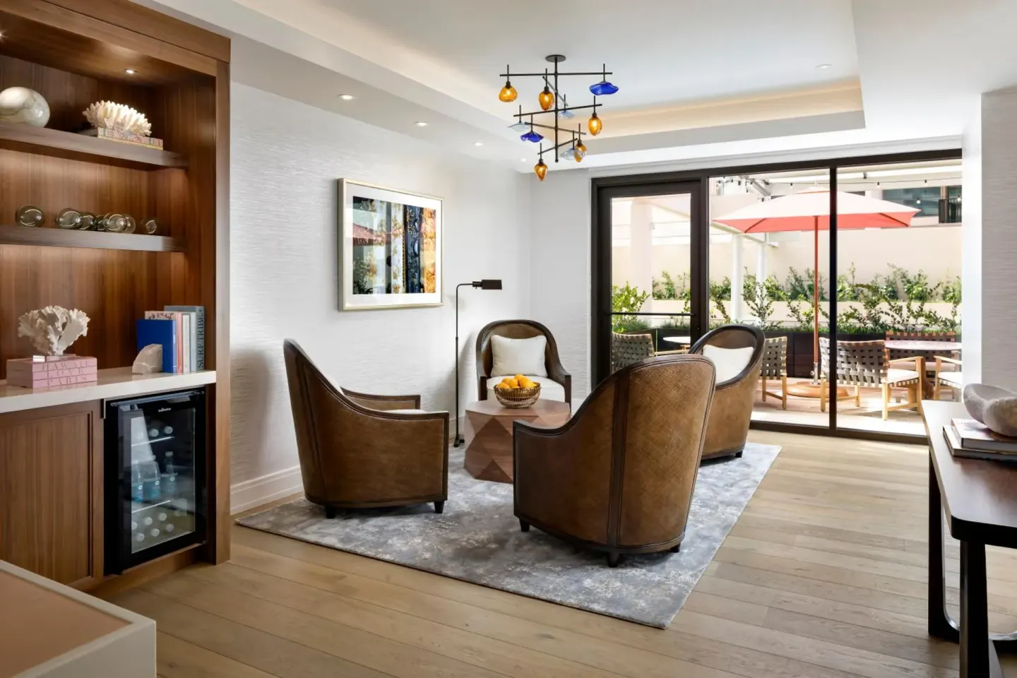 Indoor lounge with leather chairs and patio doors at Halepuna Waikiki by Halekulani.