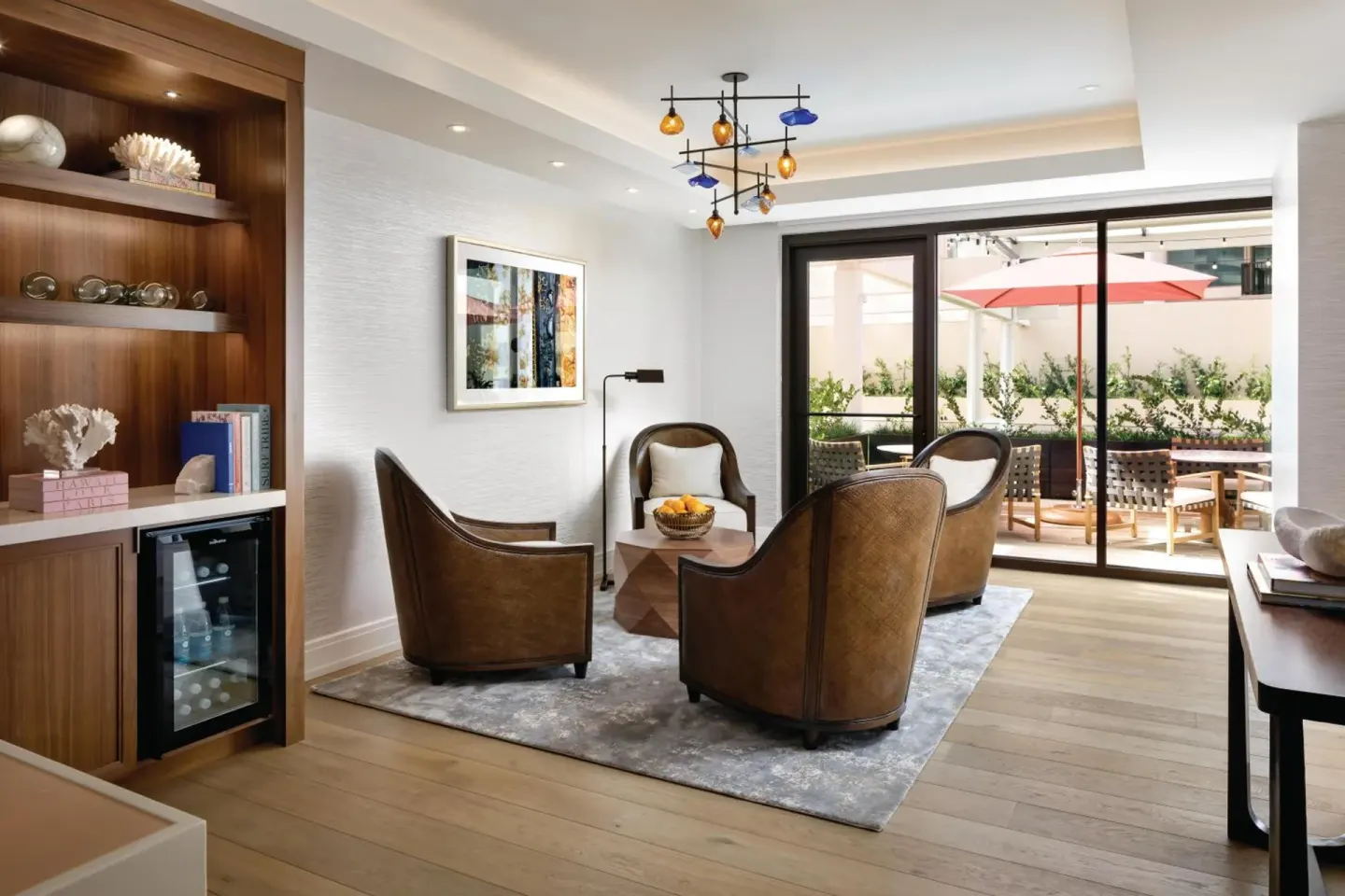 Suite living area with terrace doors and lounge chairs at Halepuna Waikiki by Halekulani.