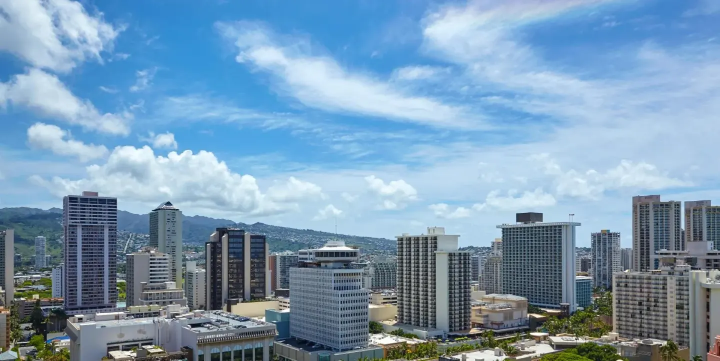 High-rise Waikiki city view under a blue sky at Halepuna Waikiki by Halekulani.