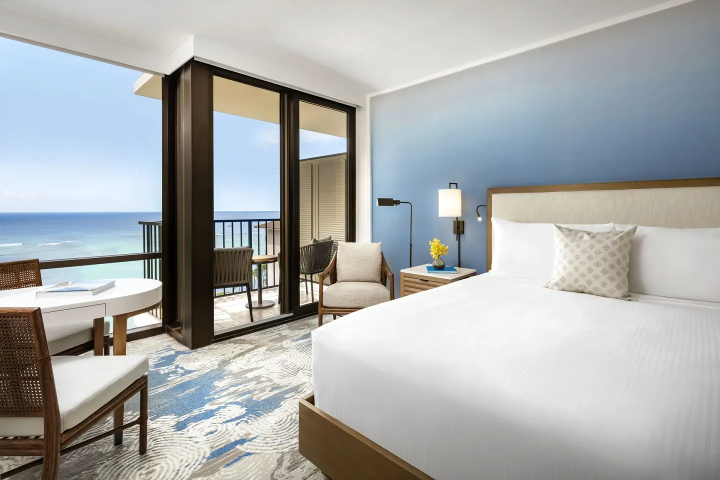 Ocean View king room with balcony and blue ocean at Halepuna Waikiki by Halekulani.