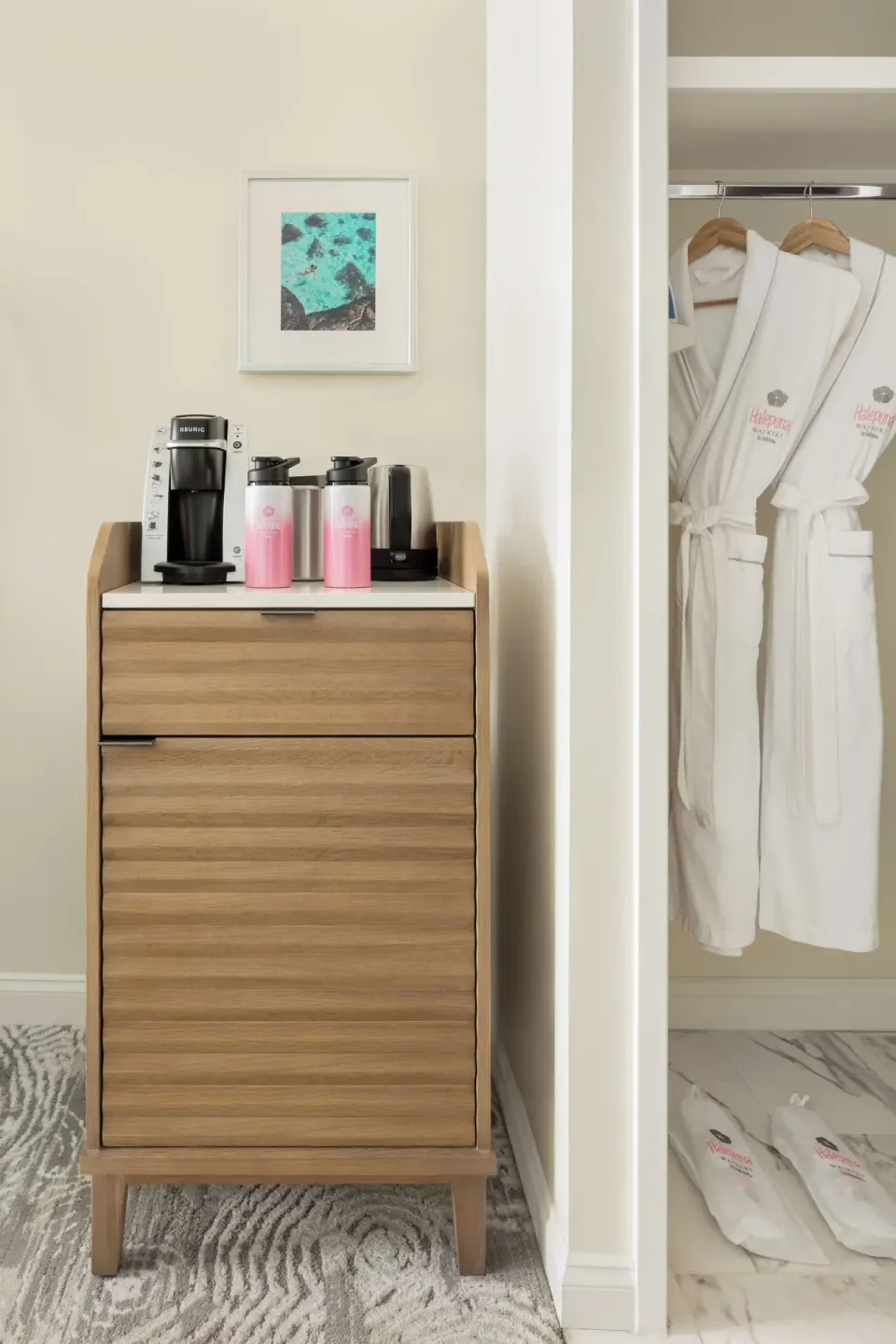 Standard Waikiki View room cabinet with coffee setup and closet robes at Halepuna Waikiki by Halekulani.