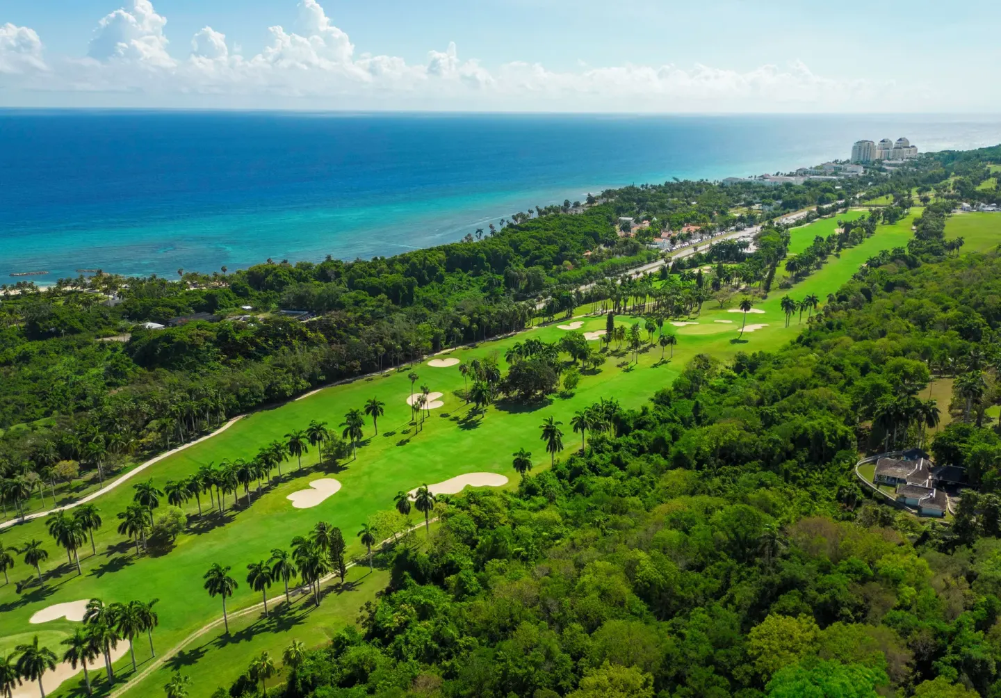 Aerial view of golf course, coastline, and blue Caribbean Sea at Half Moon.