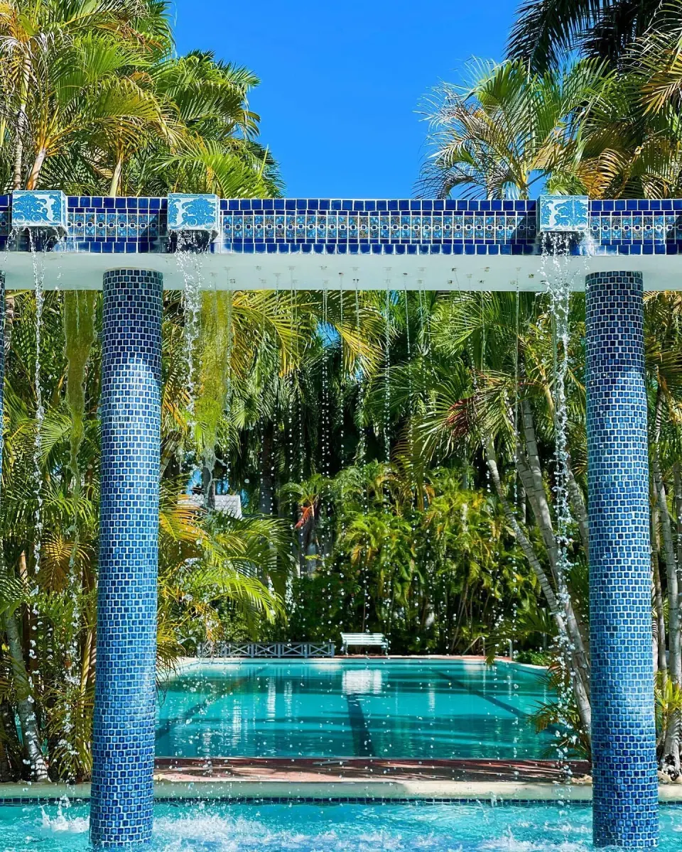 Blue-tiled fountain and pool framed by tropical palms at Half Moon.