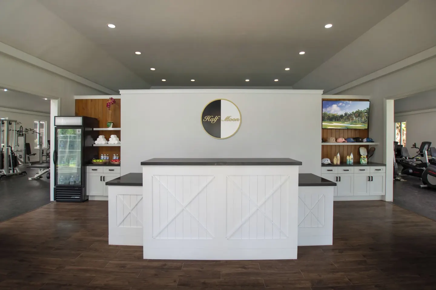 The fitness center reception desk at Half Moon sits between gym areas and display shelves.