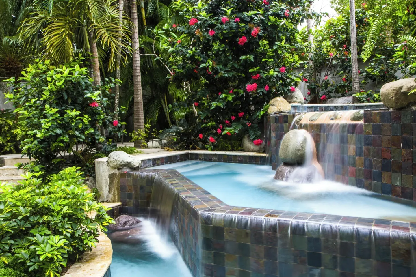 Tiered tiled waterfalls flow through lush tropical gardens at Half Moon.