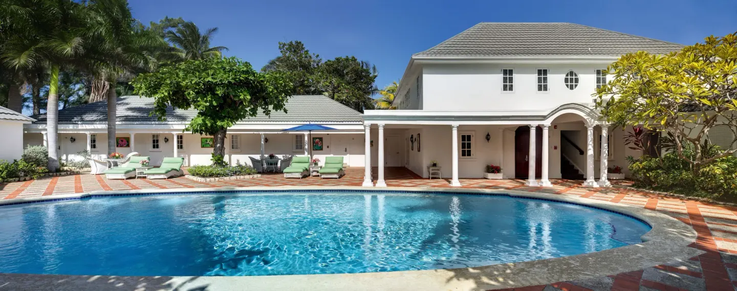 Private villa pool courtyard with loungers and white buildings at Half Moon.