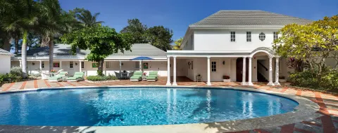 Private villa pool courtyard with loungers and white buildings at Half Moon.