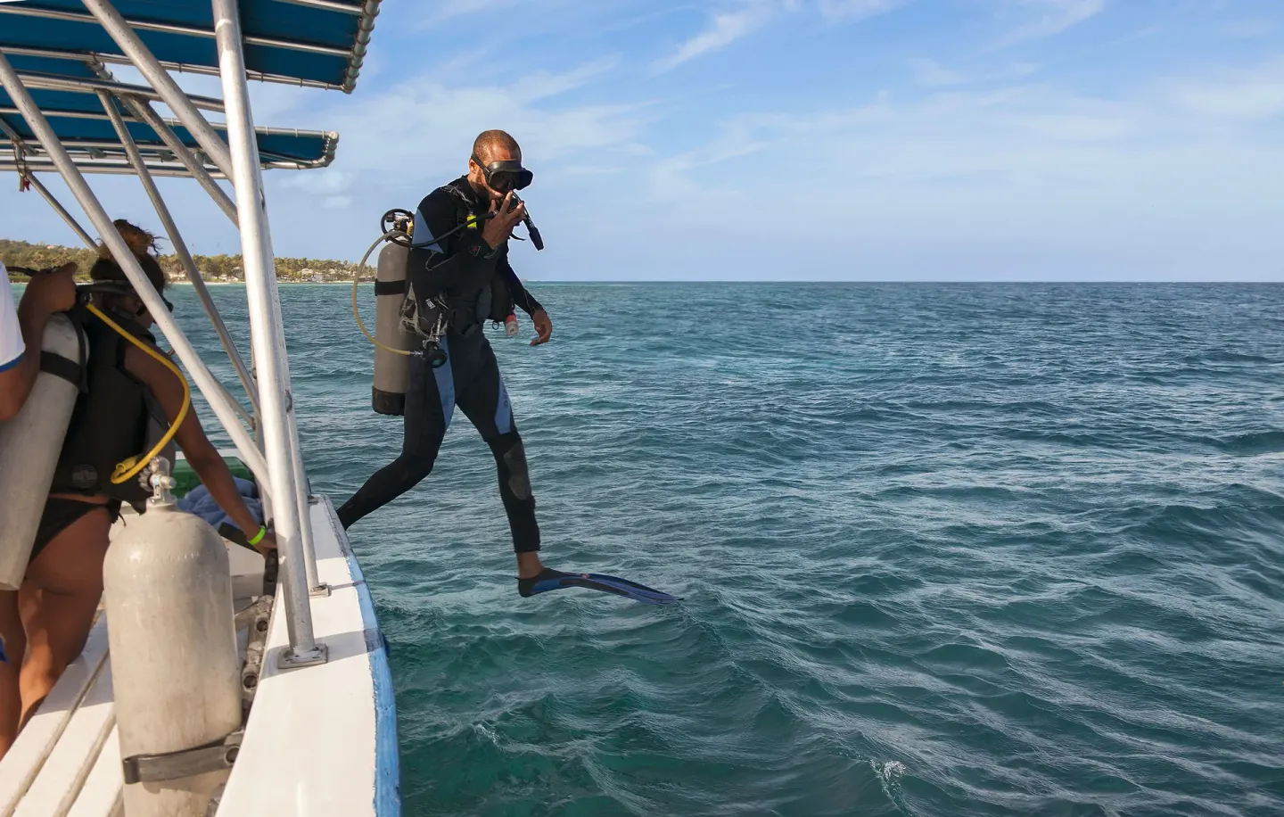 Scuba diver stepping from a boat into the sea at Half Moon.