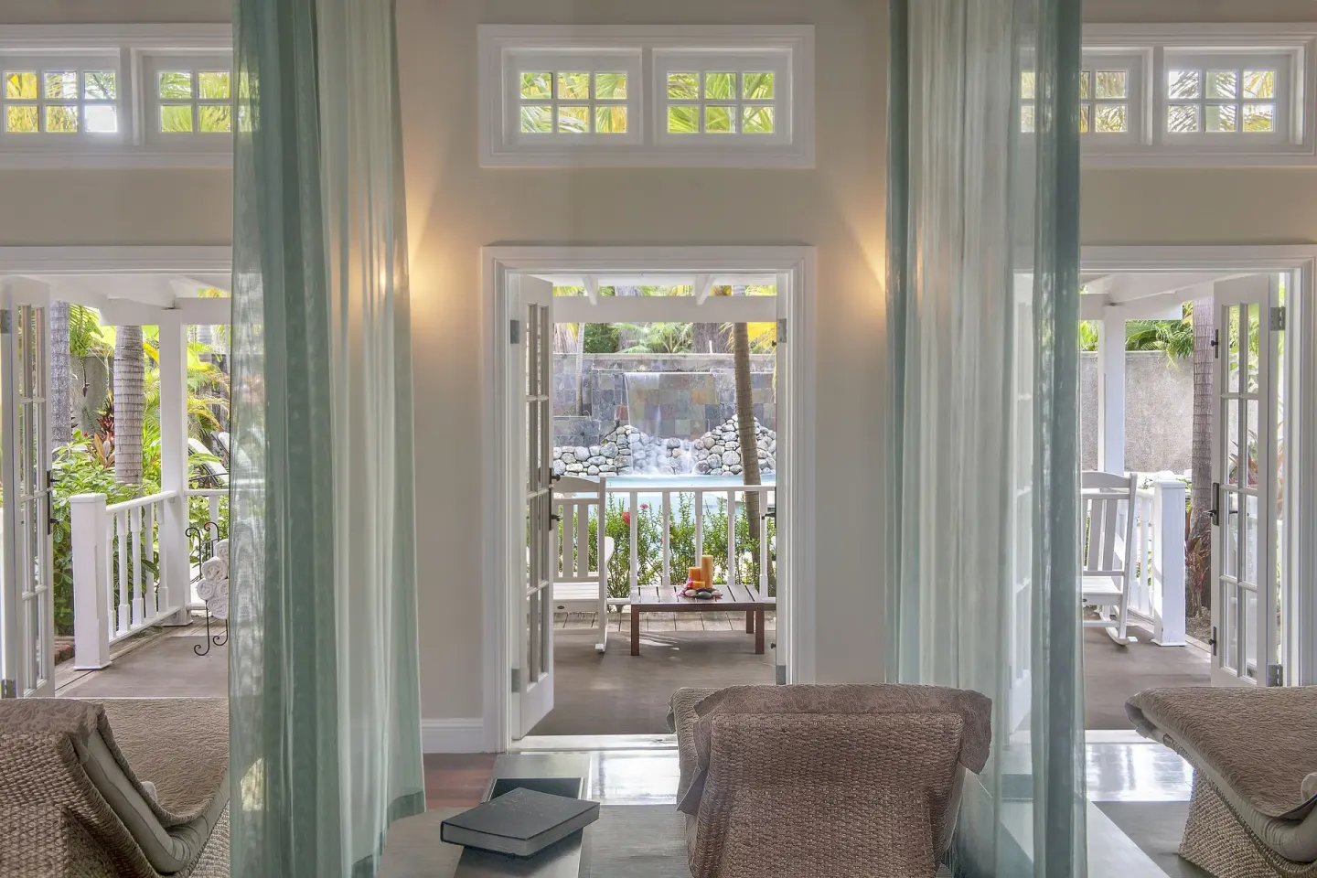 Sheer curtains frame treatment loungers and open terrace doors at Half Moon.