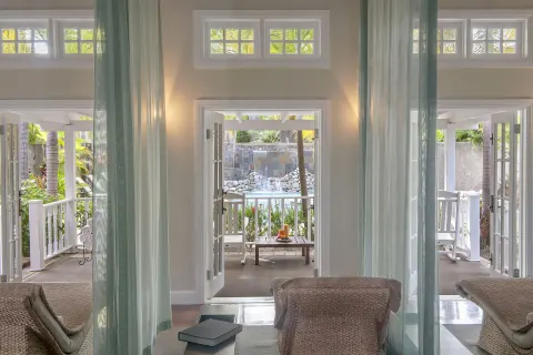 Sheer curtains frame treatment loungers and open terrace doors at Half Moon.