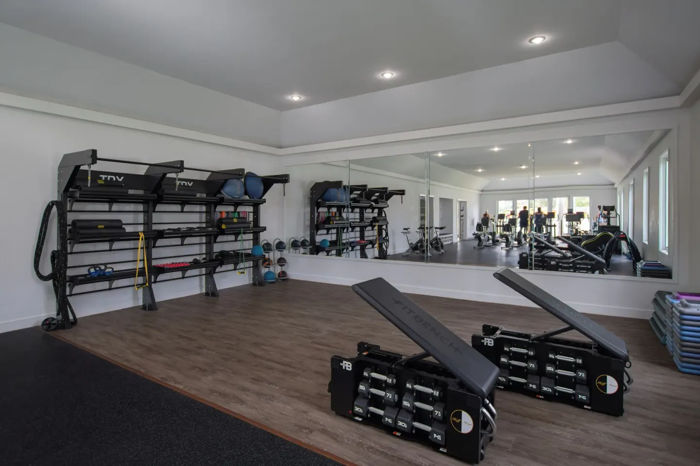 Weight benches and training equipment line a mirrored gym room at Half Moon.