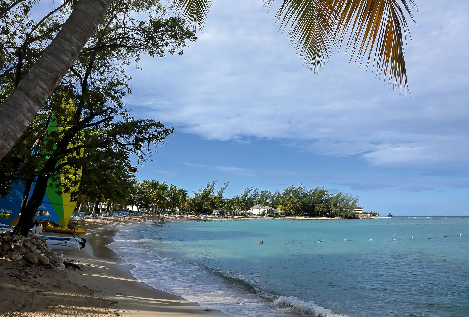 Calm turquoise bay with beach, palms and sailboats at Half Moon.