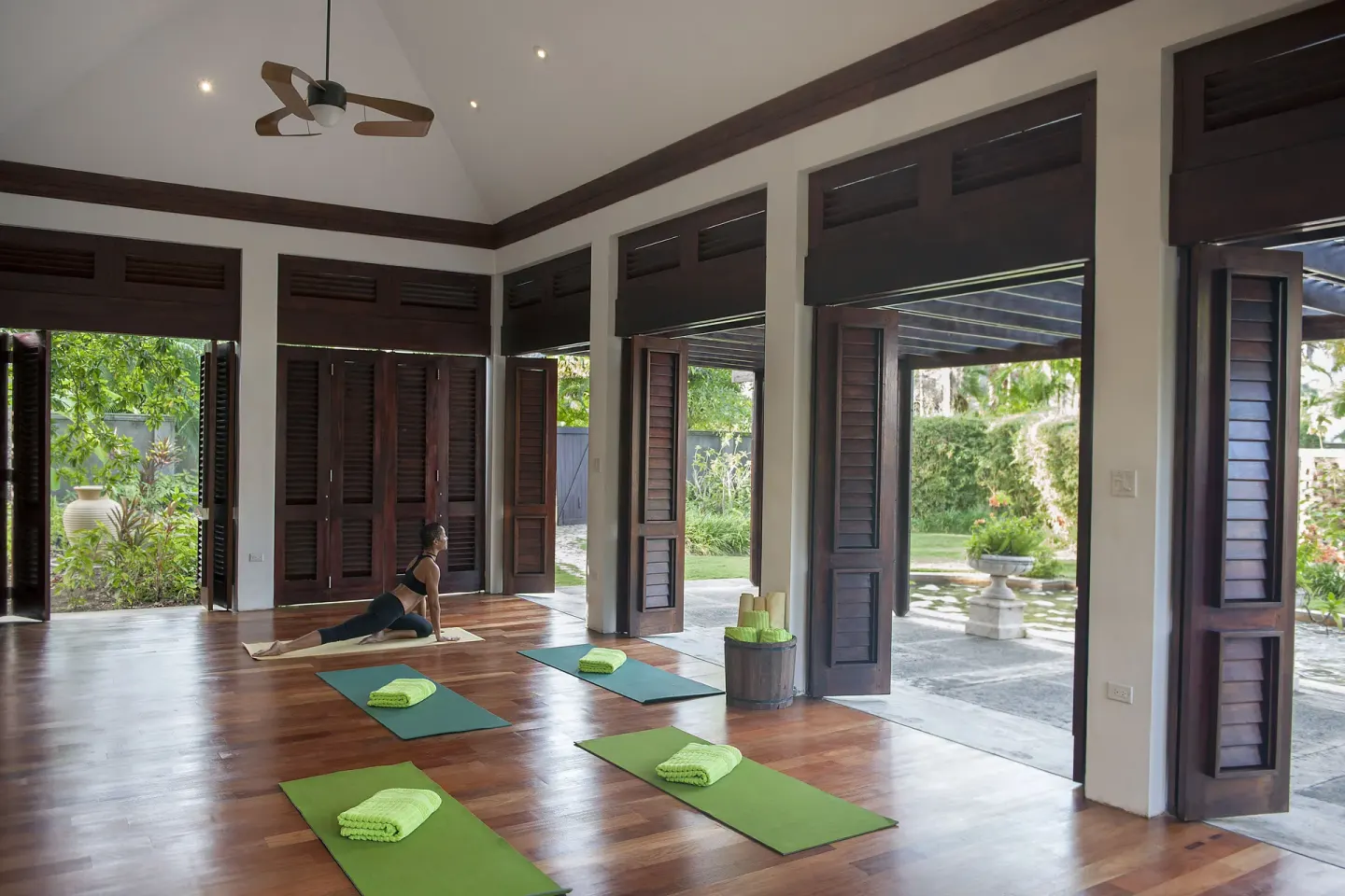 Yoga mats with folded towels are set in an airy wooden studio at Half Moon.