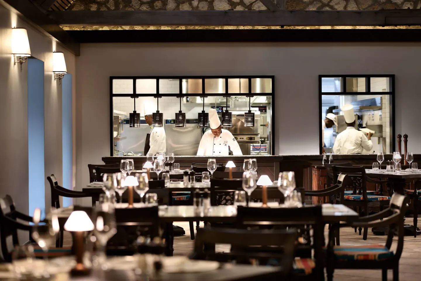 Dining room tables and chefs visible through kitchen windows at Half Moon.