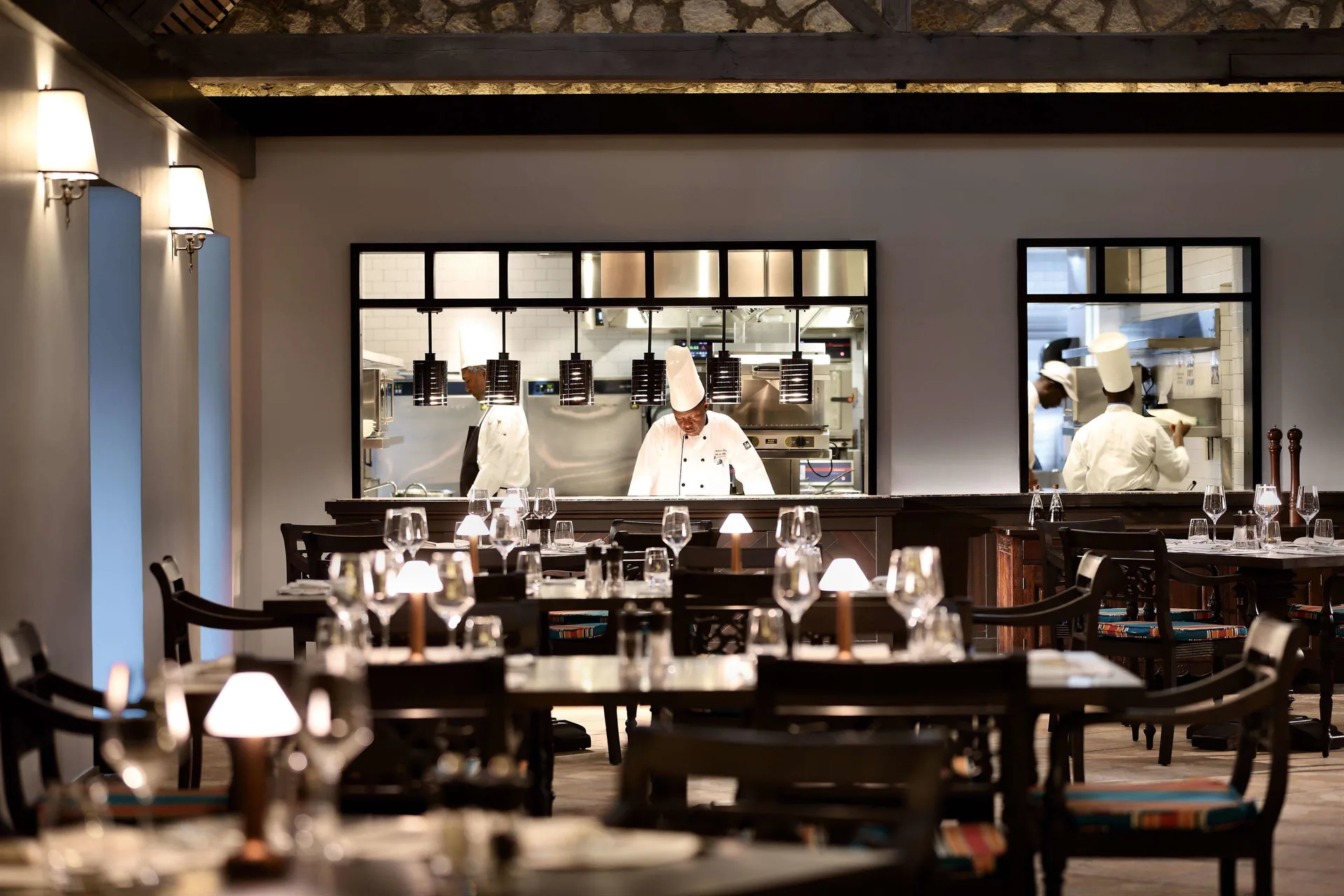 Dining room tables and chefs visible through kitchen windows at Half Moon.
