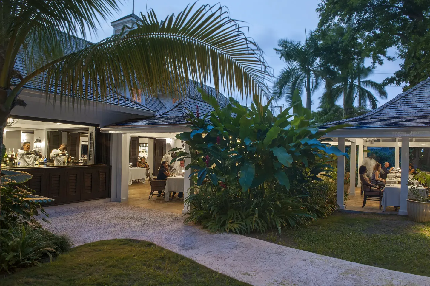 Guests dine beside an open bar in a garden courtyard at Half Moon.