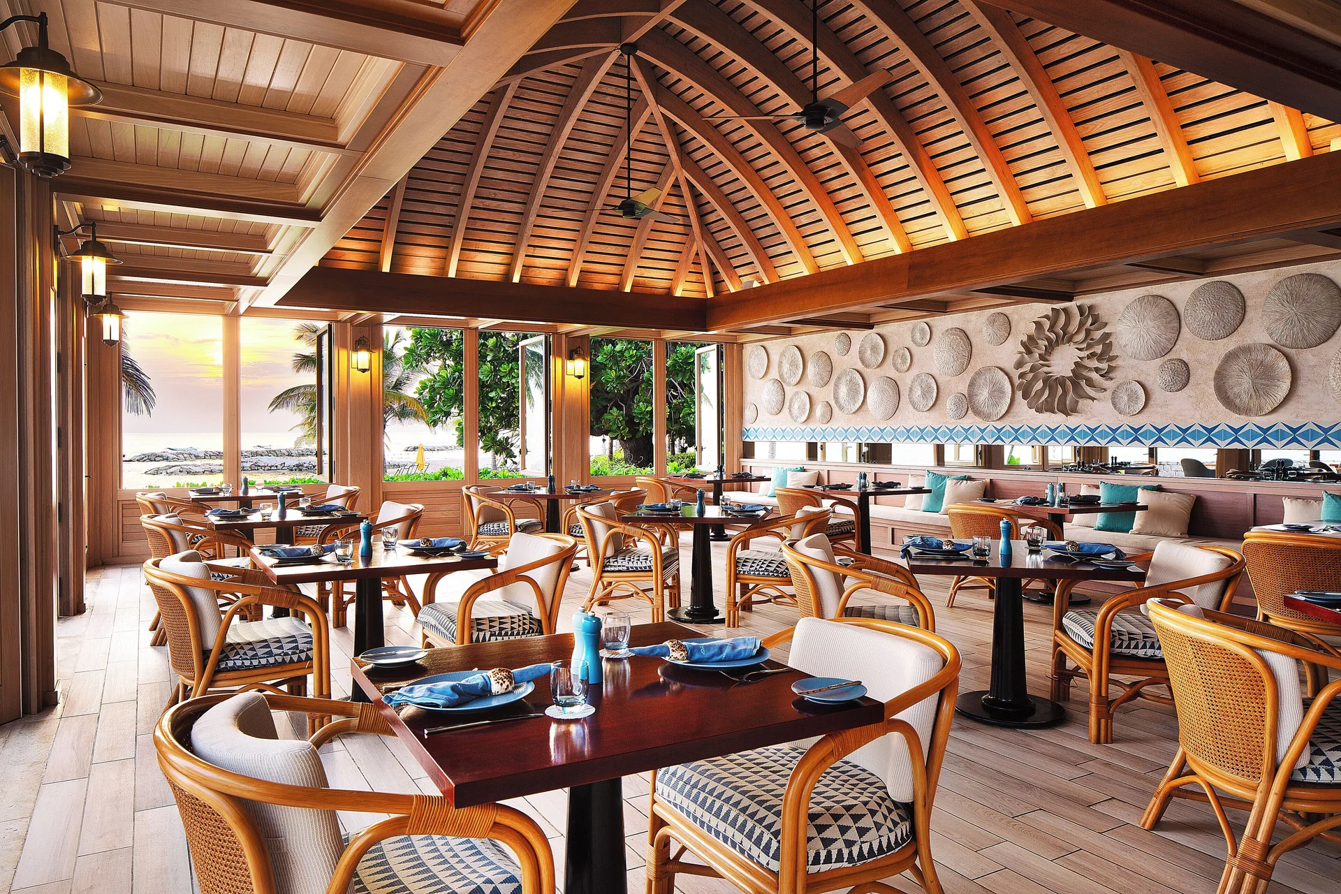 Open-air seaside restaurant with rattan chairs and ocean views at Half Moon.