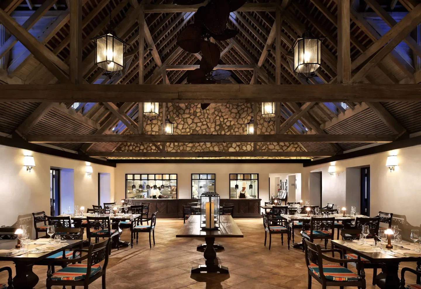 High-ceiling dining room with open kitchen windows at Half Moon.