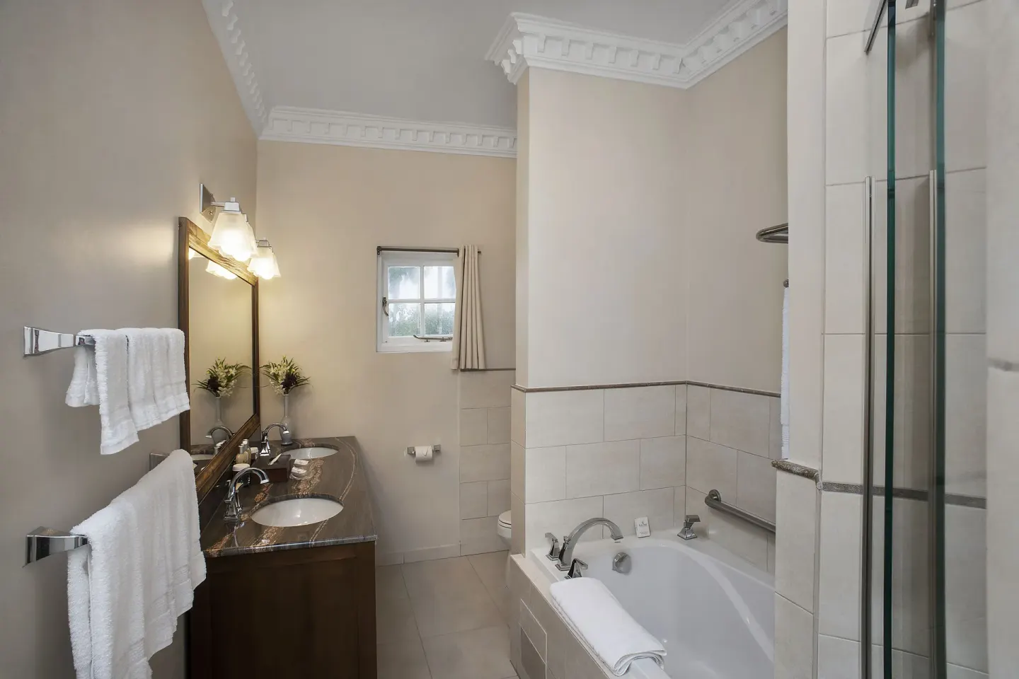 Bathroom in the 6 Bedroom Garden View Villa at Half Moon with tub, vanity, and glass shower.