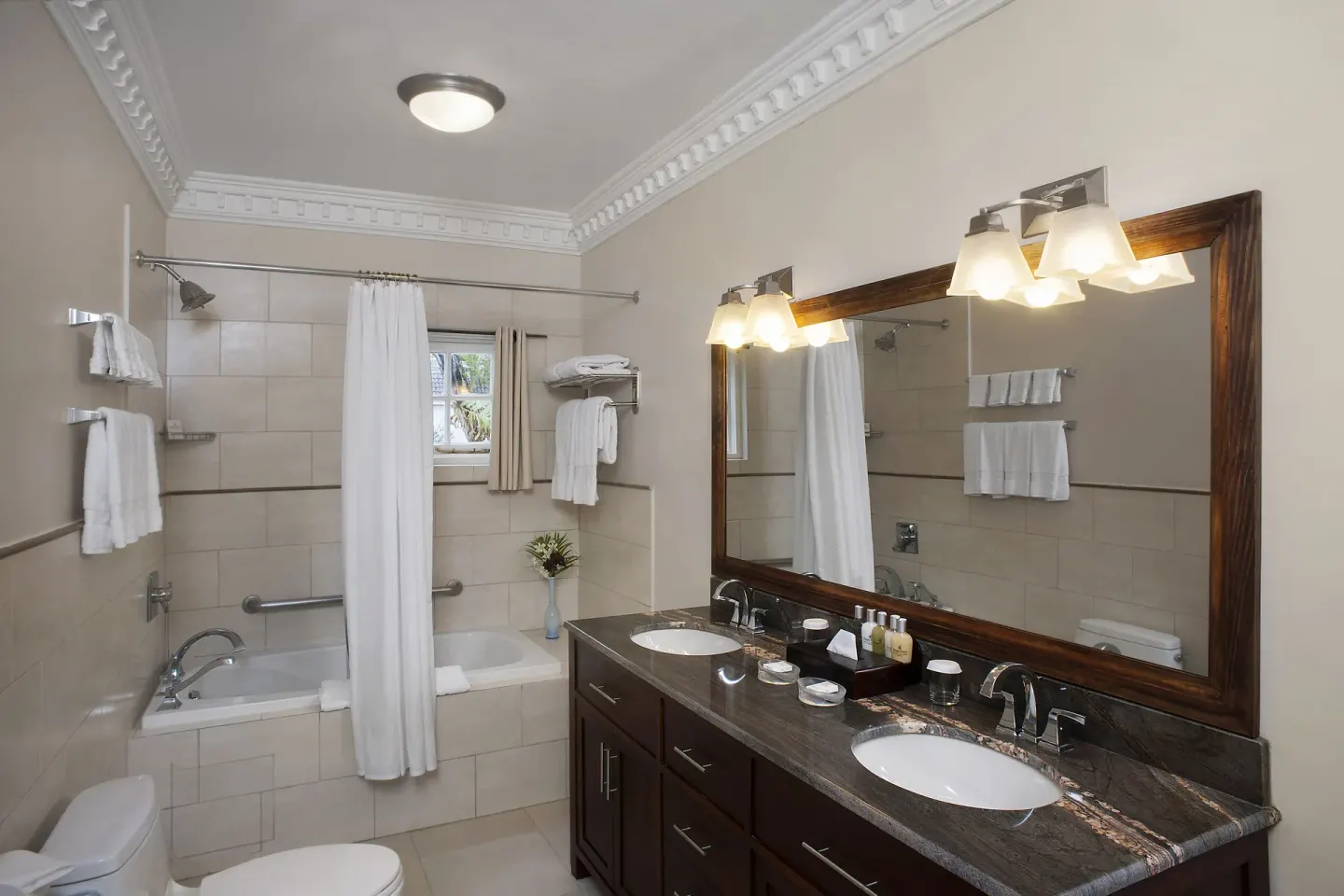 Double-sink bathroom in the 6 Bedroom Garden View Villa at Half Moon with tub and shower curtain.