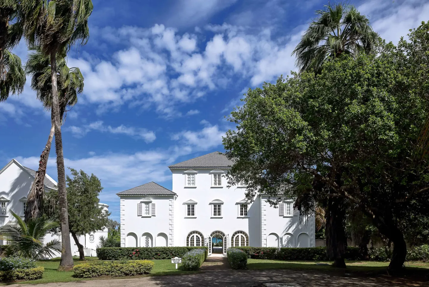 White ocean-view villa exterior among palms and gardens at Half Moon.
