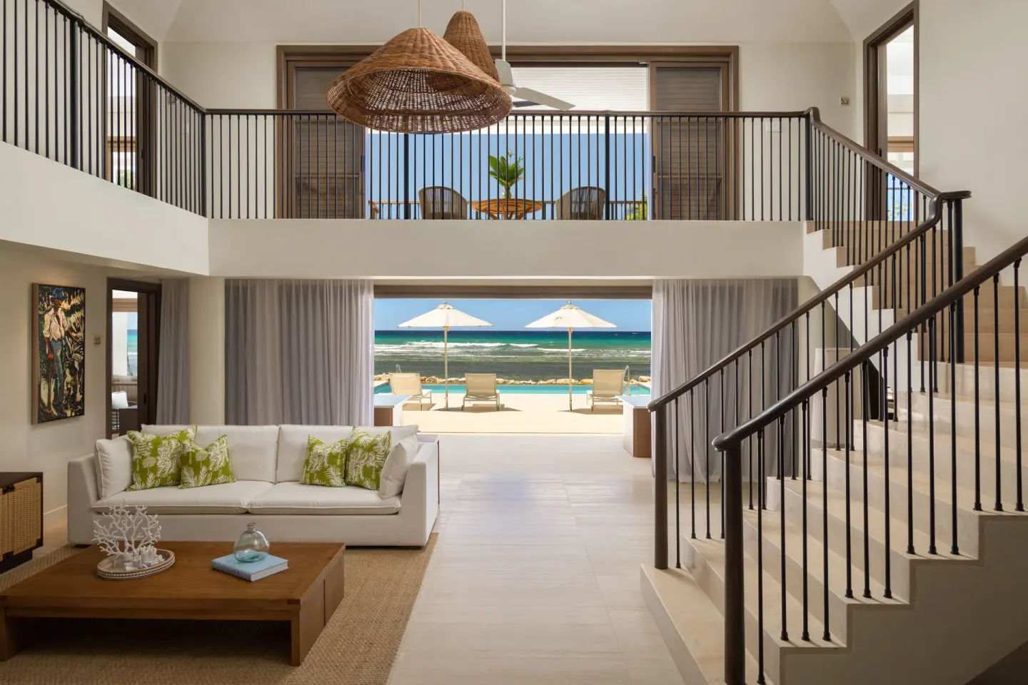 Ocean-view villa living room with loft, staircase, and terrace at Half Moon.