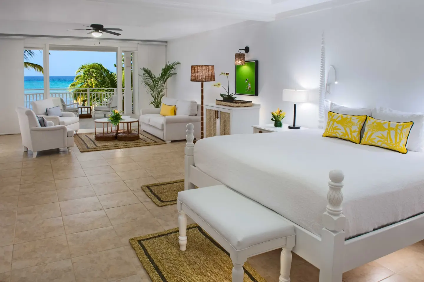 Junior Suite Ocean with white bed, lounge area, balcony, and sea view at Half Moon.