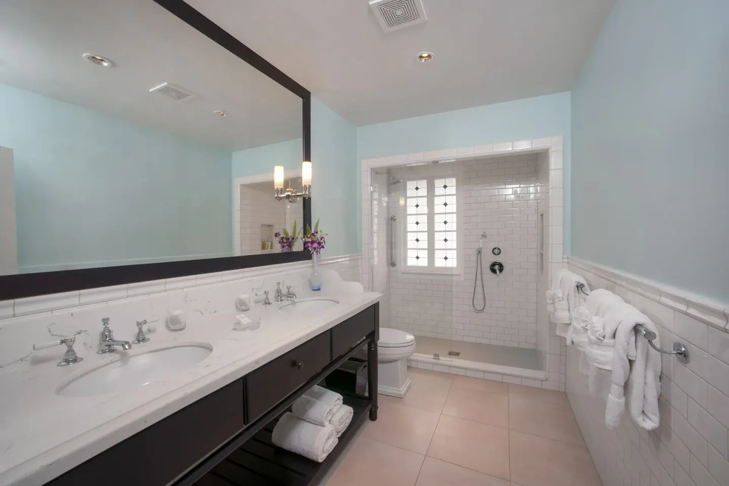 Junior Suite bathroom with double vanity and glass shower at Half Moon.