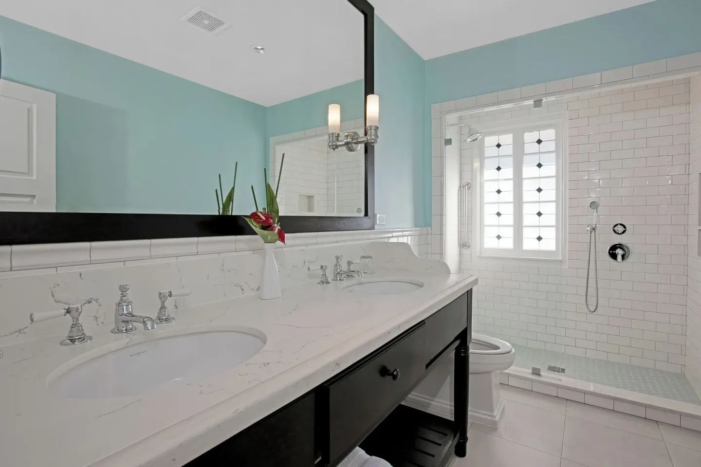 Junior Suite bathroom vanity and tiled shower with window at Half Moon.