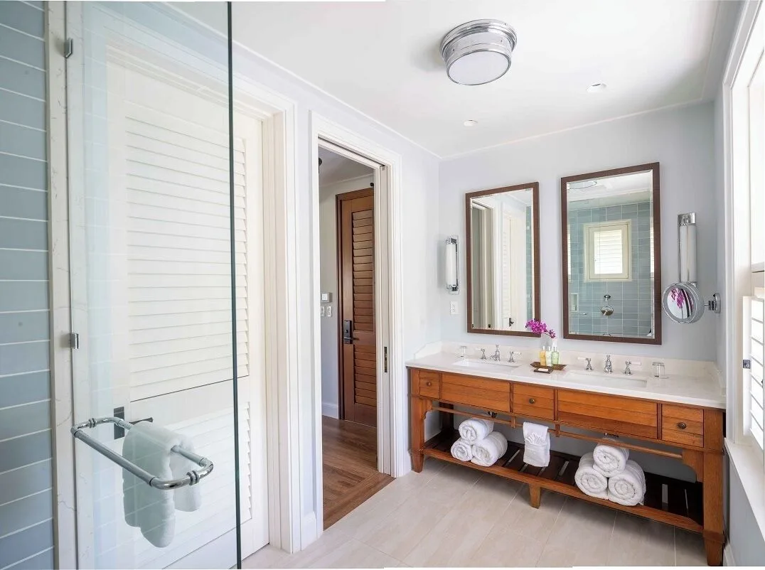 Guest room bathroom with double vanity and glass shower at Half Moon.