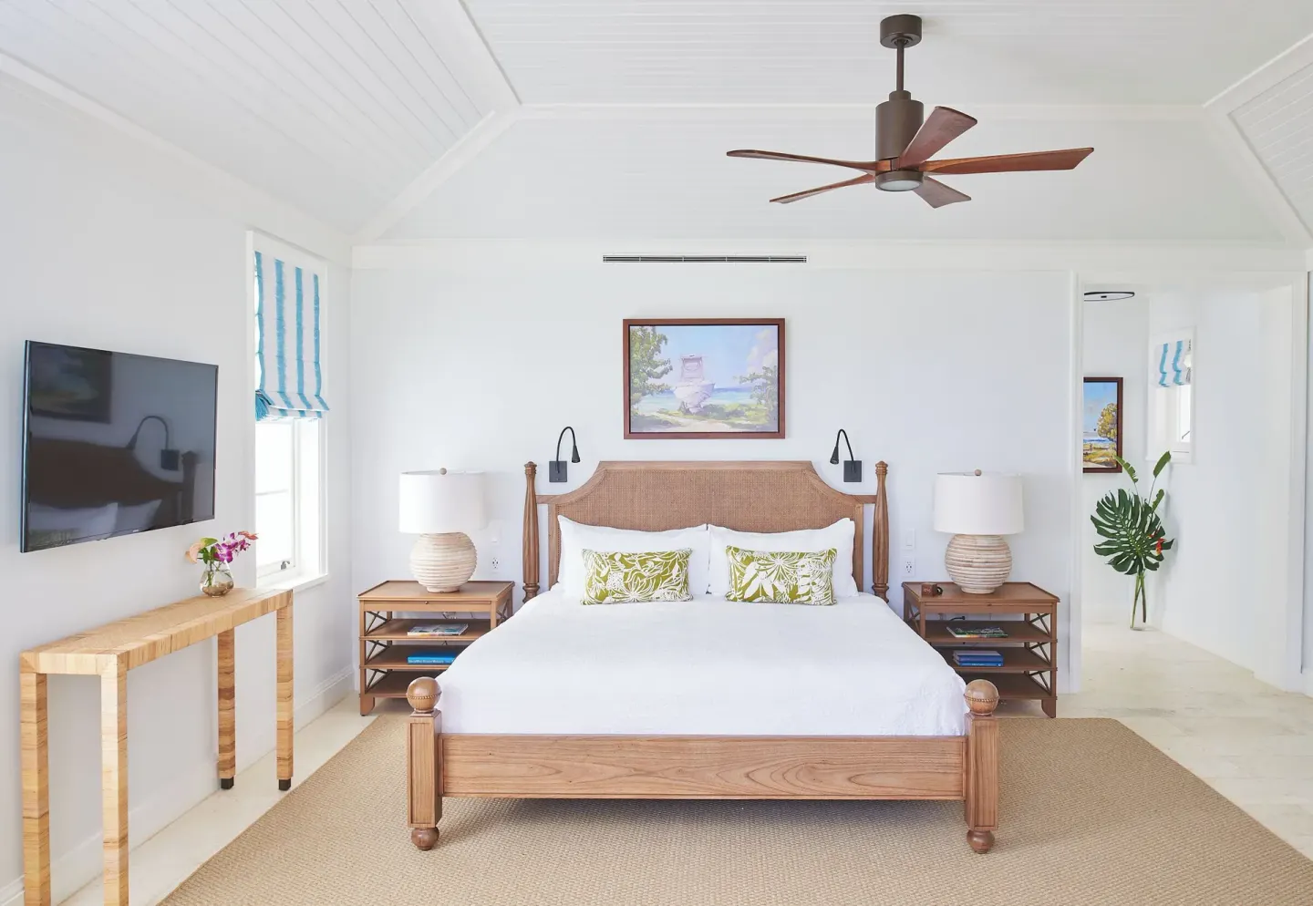 Ocean Estate Suite bedroom with king bed, TV and white vaulted ceiling at Half Moon.
