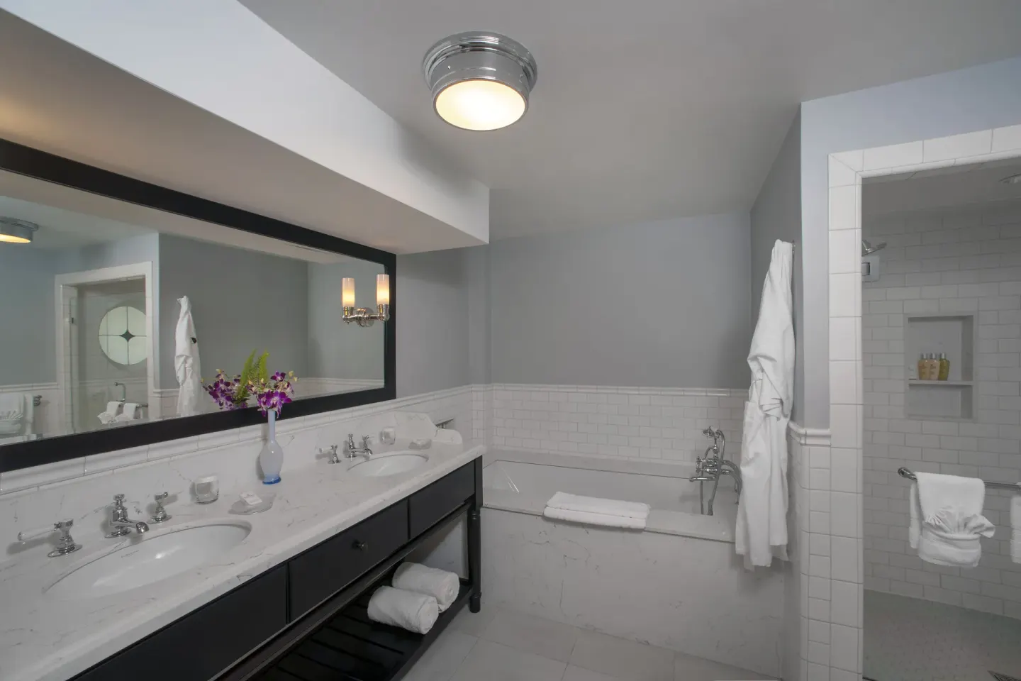 Ocean Suite bathroom with double vanity, tub, and shower at Half Moon.