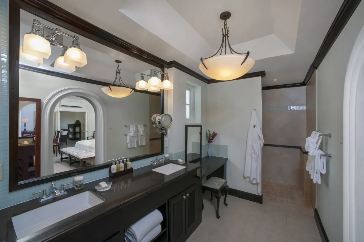 Suite bathroom with double vanity, robes, and walk-in shower at Half Moon.