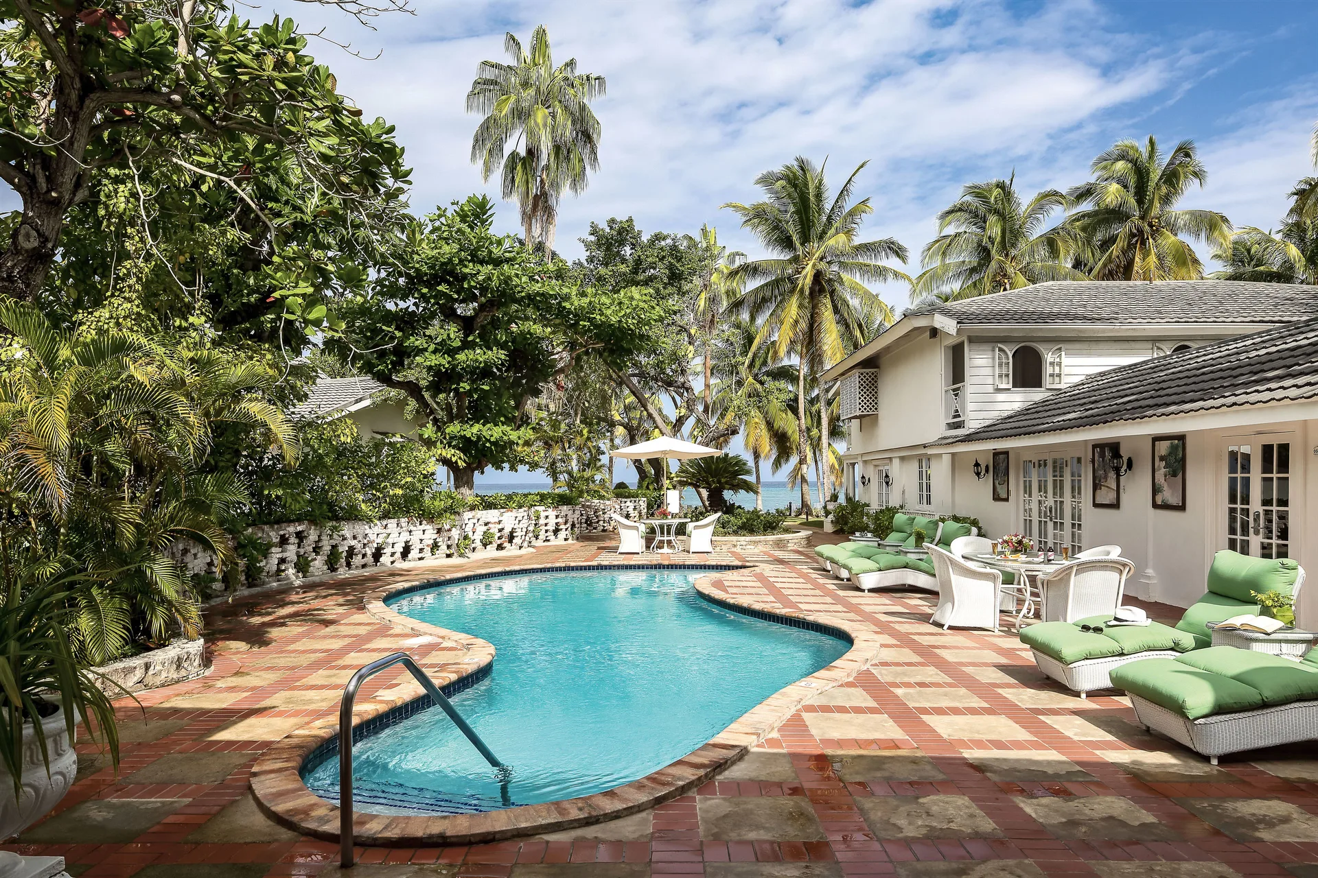 Private suite pool terrace with loungers and palm trees at Half Moon.